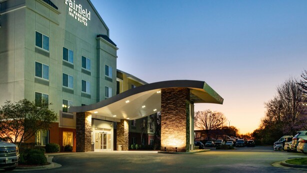 Un hôtel Fairfield Inn & Suites au design moderne, doté d’un auvent incurvé à l’entrée et d’un parking.