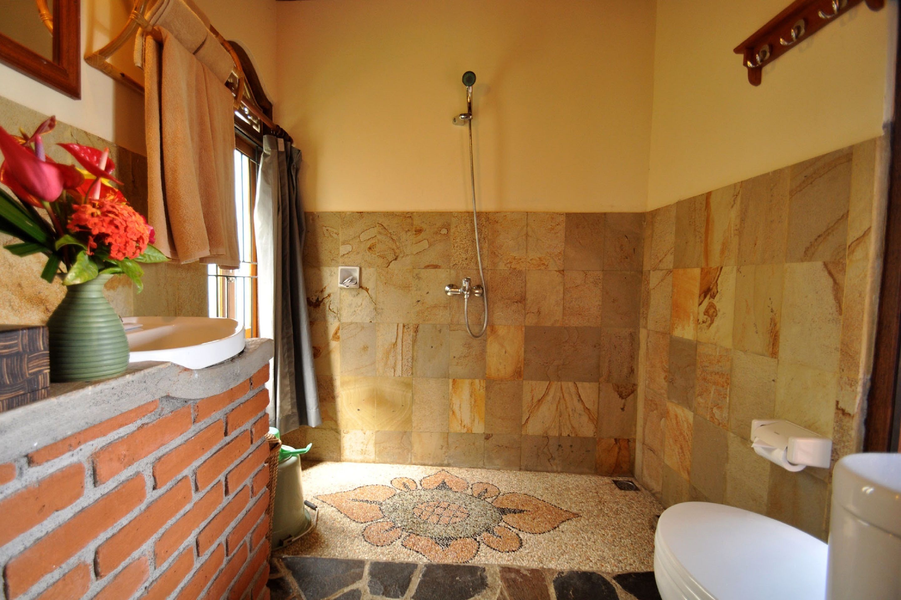 A bathroom with a shower, a toilet, and a sink.