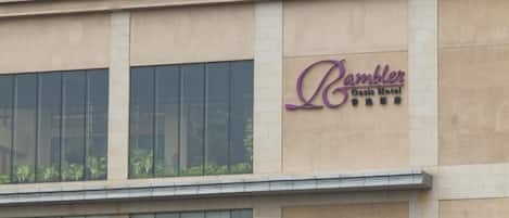 A building with a sign for 'Rambler Oasis Hotel' on the facade.