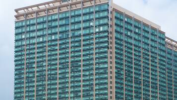 A high-rise hotel with a modern glass facade, multiple floors, and a prominent entrance at the base.