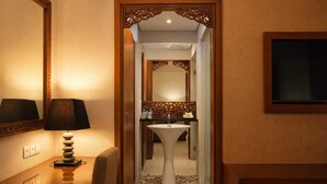 A hotel bathroom with a sink, mirror, and a decorative wooden frame.