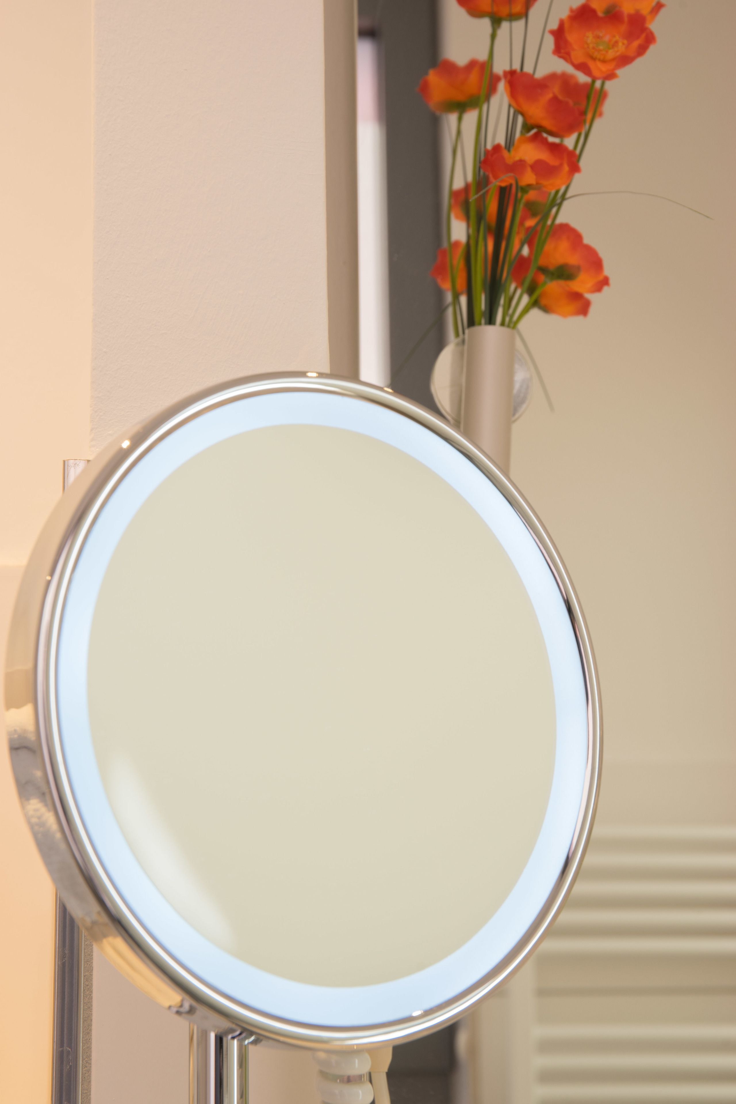 A bathroom mirror with a white frame and a clear glass surface.