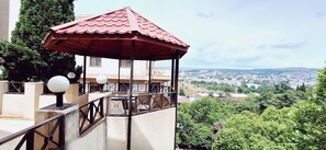 Relax on the balcony overlooking the city, taking in the sights from a gazebo with a glass top.