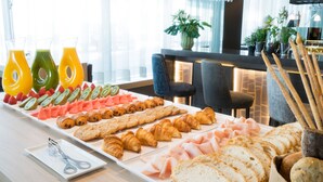 A breakfast buffet with various pastries, fruits, and bread.