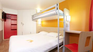 A bunk bed with a desk and chair, a television, and a red wardrobe in a hotel room.