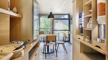 Una cocina moderna con armarios de madera, una mesa redonda de comedor y sillas.