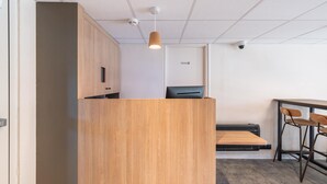 Una recepción con detalles de madera, una lámpara en el techo, una cámara de seguridad e impresora.
