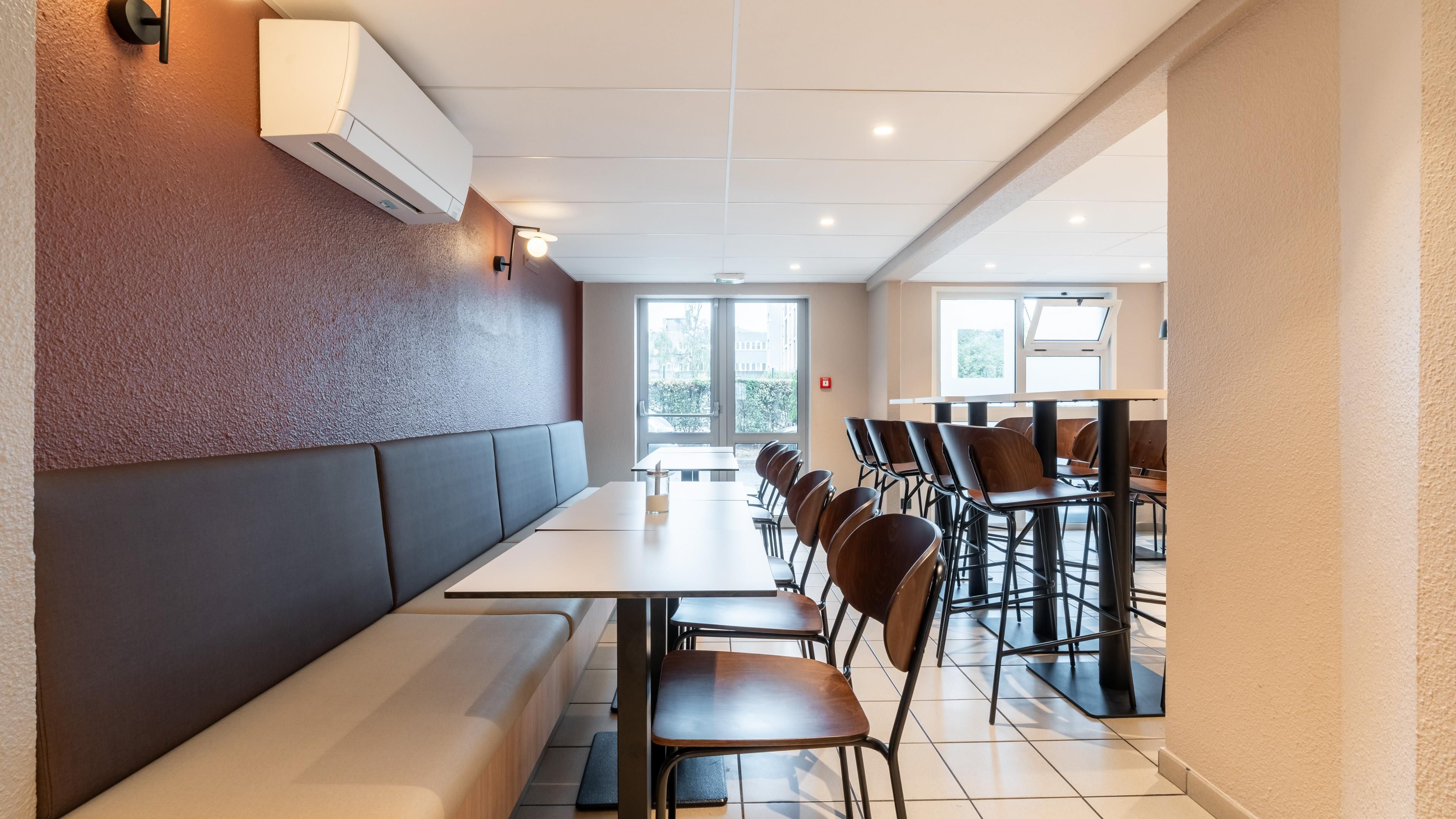 A restaurant with a long counter, booths, and high chairs.