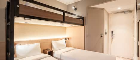 A bedroom with two beds, a wardrobe, and a bedside table.