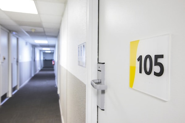 A hallway with a door marked '105' and a doorbell. - Kyriad ECO - Montreuil (Montreuil)