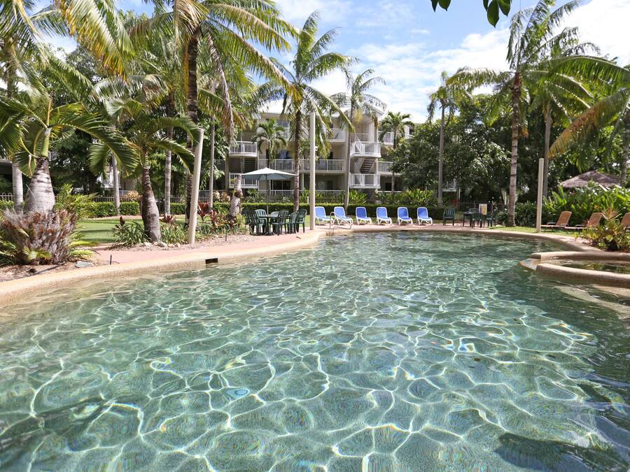 Una piscina al aire libre, sombrillas, tumbonas