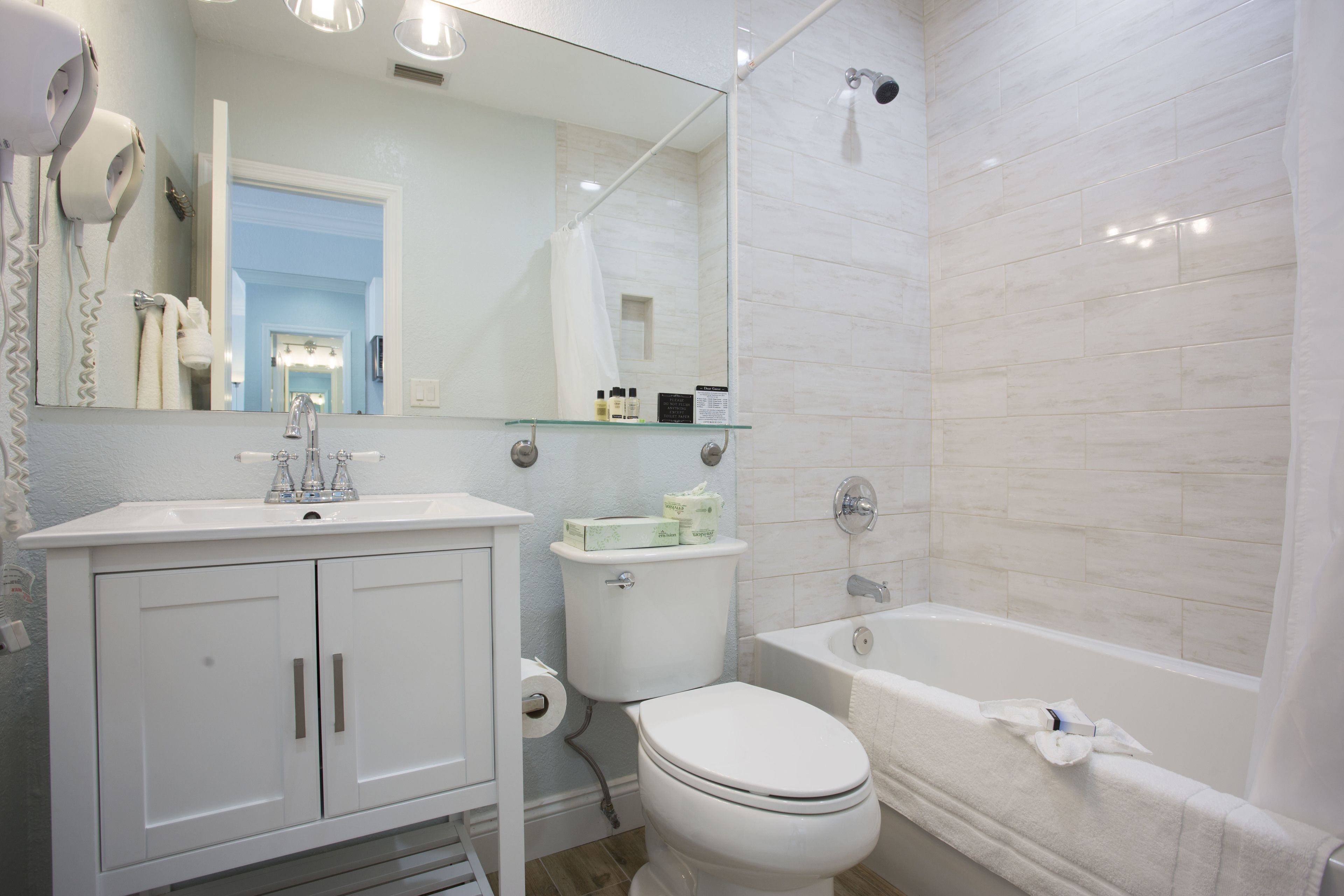 Une salle de bain moderne avec un lavabo blanc, un meuble-lavabo, des toilettes et une baignoire.