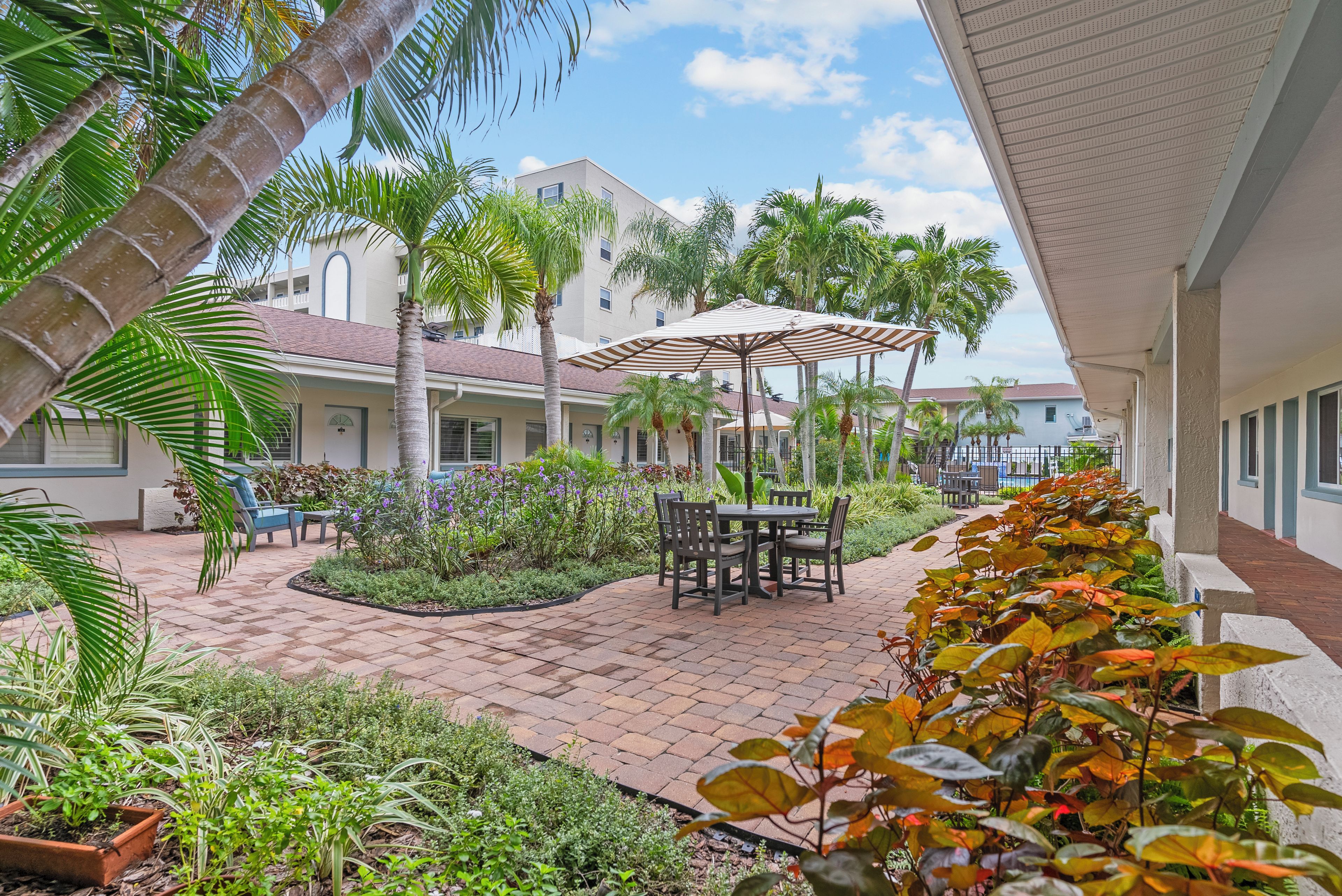 A courtyard with a patio area, outdoor seating, and a pool.