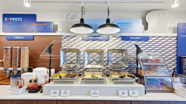 A buffet area with labeled sections for cereal, hot food, and bakery. - Holiday Inn Express & Suites Bethlehem Arpt-Allentown Area (Bethlehem)