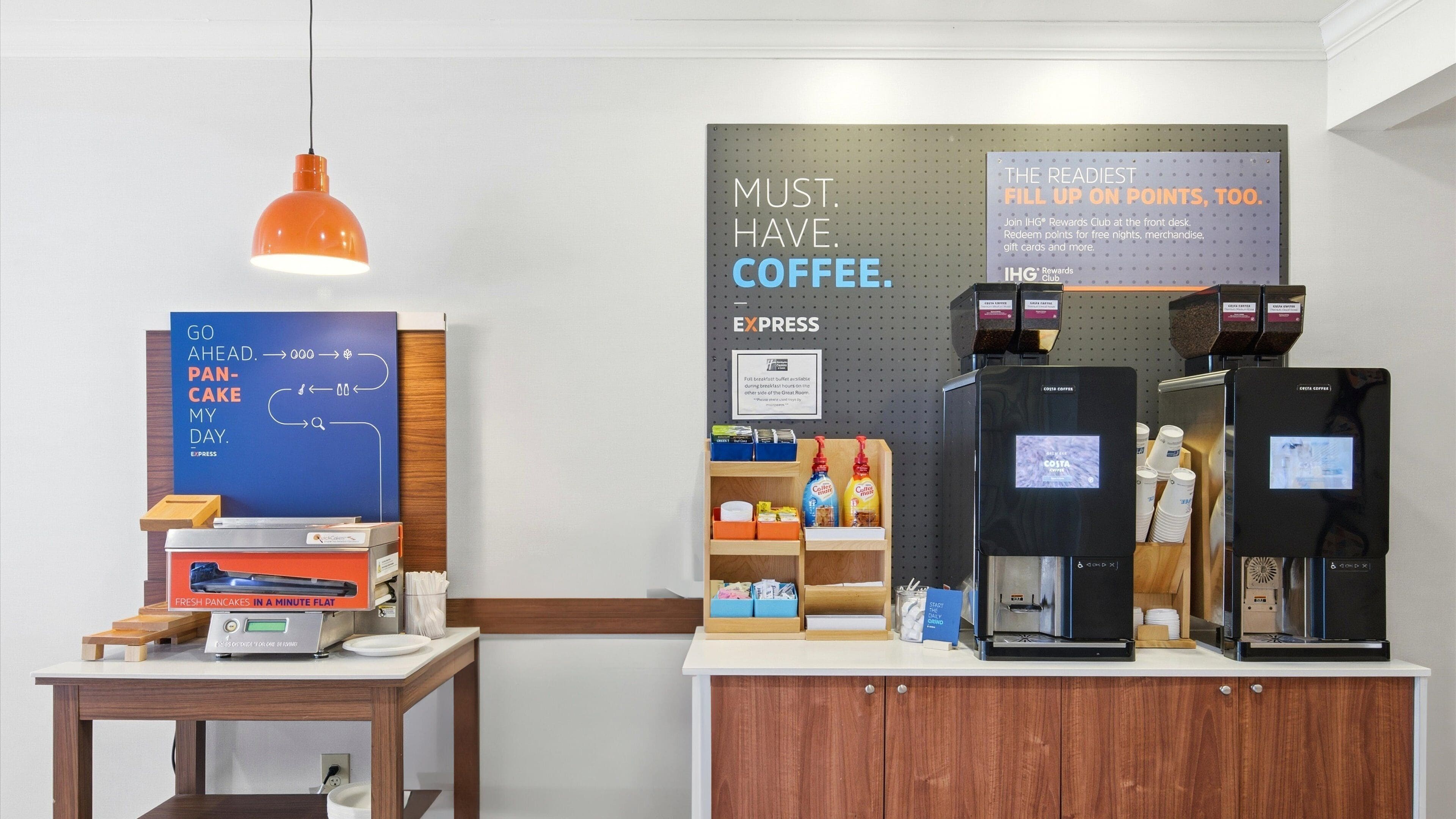 A coffee station with a sign that reads "MUST. HAVE. COFFEE." and a sign for the IHG Rewards Club.