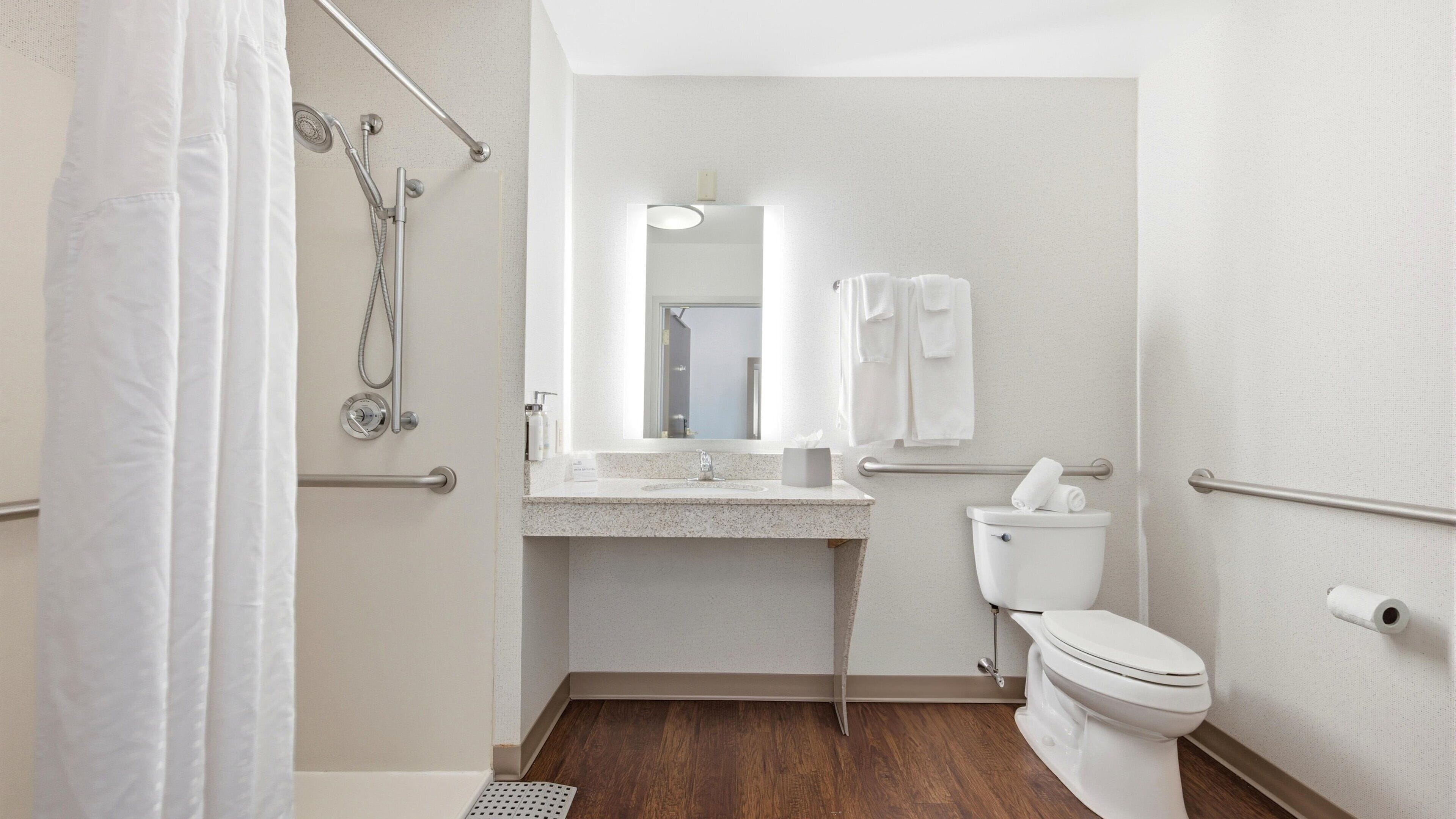 Ein kleines, modernes Badezimmer mit Dusche, Toilette und Waschbecken.