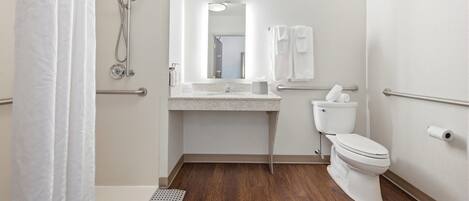 Ein kleines, modernes Badezimmer mit Dusche, Toilette und Waschbecken.