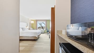 Une chambre d’hôtel avec un lit, un bureau et un four à micro-ondes.