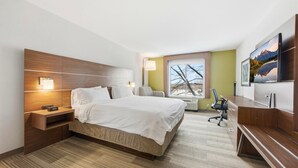 A hotel room with a large bed, bedside tables, a desk, a chair, a TV, and a window with a view of trees. - Holiday Inn Express & Suites Bethlehem Arpt-Allentown Area (Bethlehem)