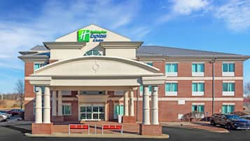 Edificio de Holiday Inn Express & Suites con fachada de ladrillo, un acceso cubierto y un estacionamiento.
