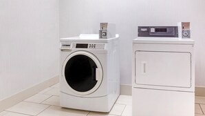 Une buanderie équipée d’un lave-linge à chargement frontal et d’un sèche-linge superposé.