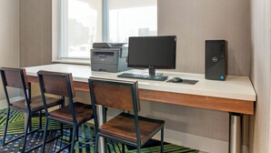Une chambre d’hôtel équipée d’un bureau, d’un ordinateur, d’une imprimante et de deux chaises.