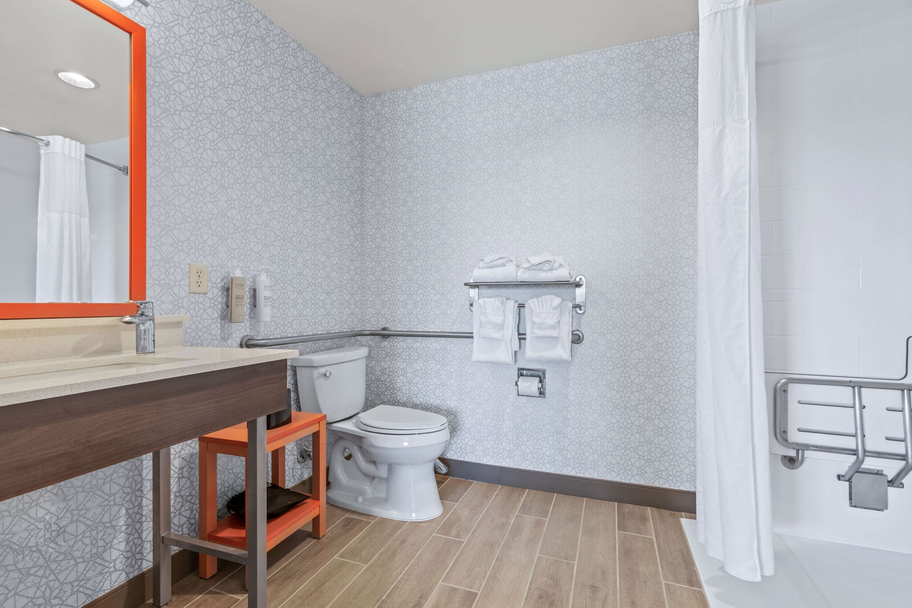 A modern bathroom with a toilet, sink, and shower area.