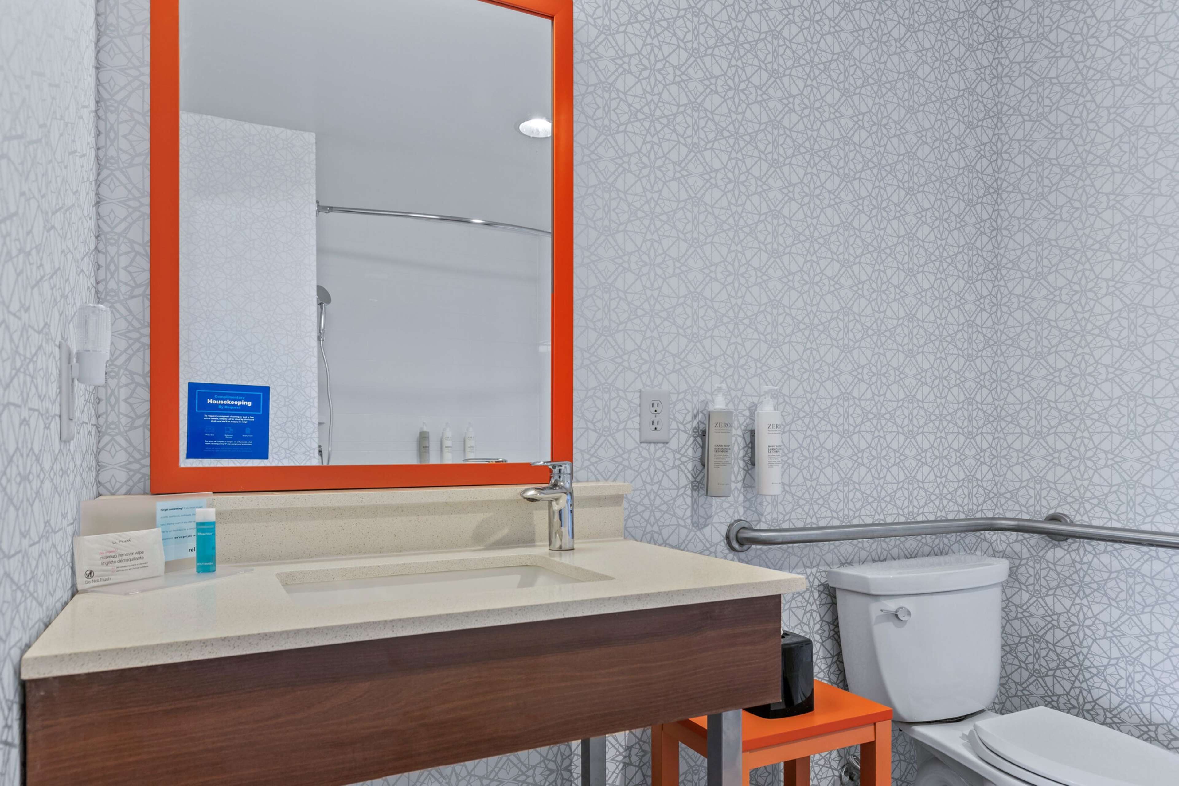 A bathroom with a sink, mirror, and toilet.