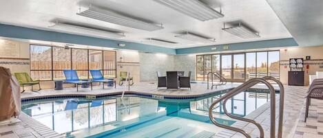 An indoor swimming pool with lounge chairs and a sun terrace.