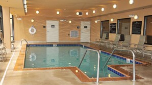A swimming pool with a tiled edge, a lifeguard station, and a sign indicating no lifeguard on duty.