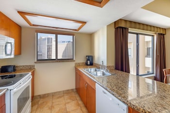 A gym with various exercise machines, a reception desk, and large windows offering a view of the outside. at Hilton Vacation Club Polo Towers Las Vegas