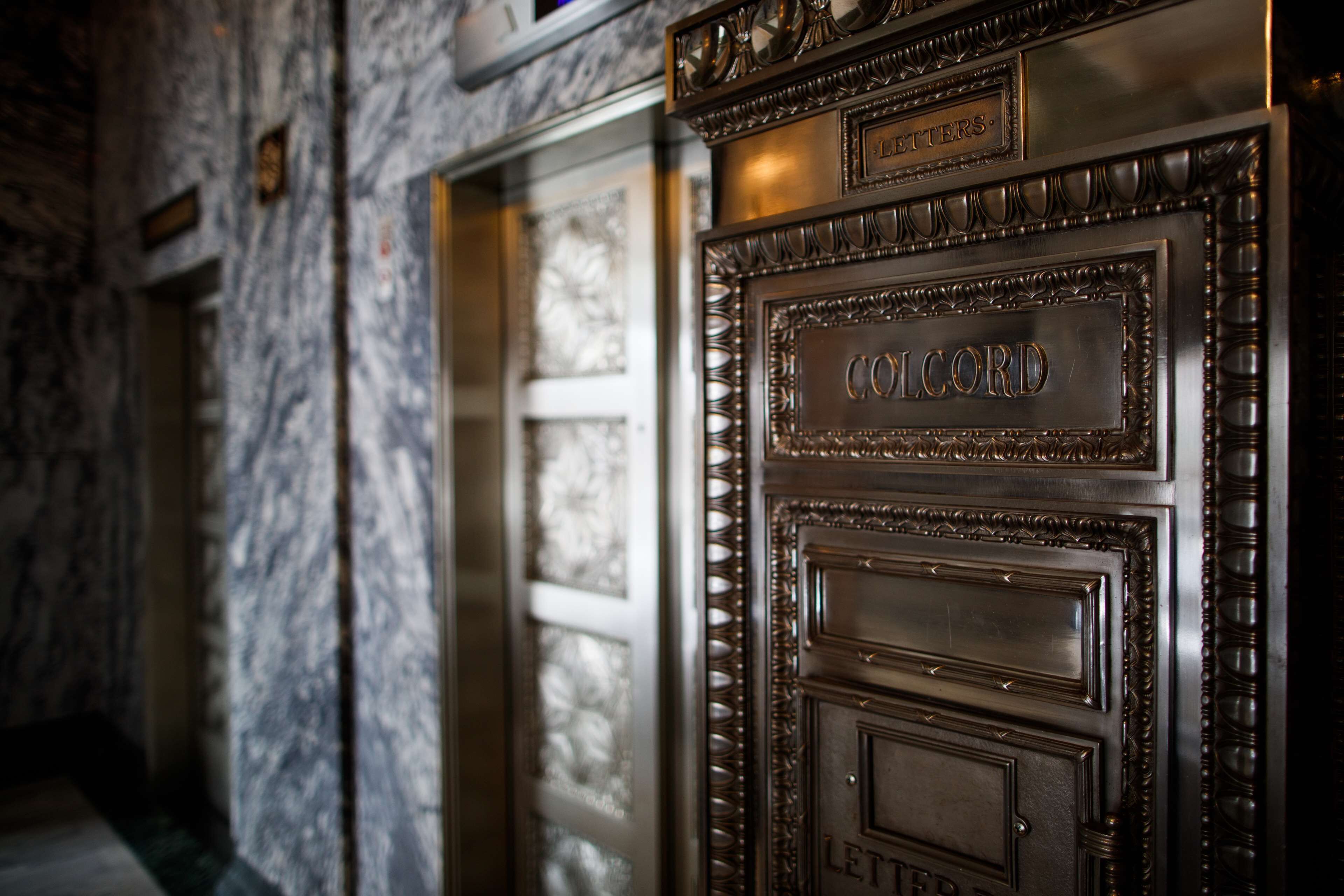A close-up of a metallic door with the nameplate 'COLCORD LETTERS'.