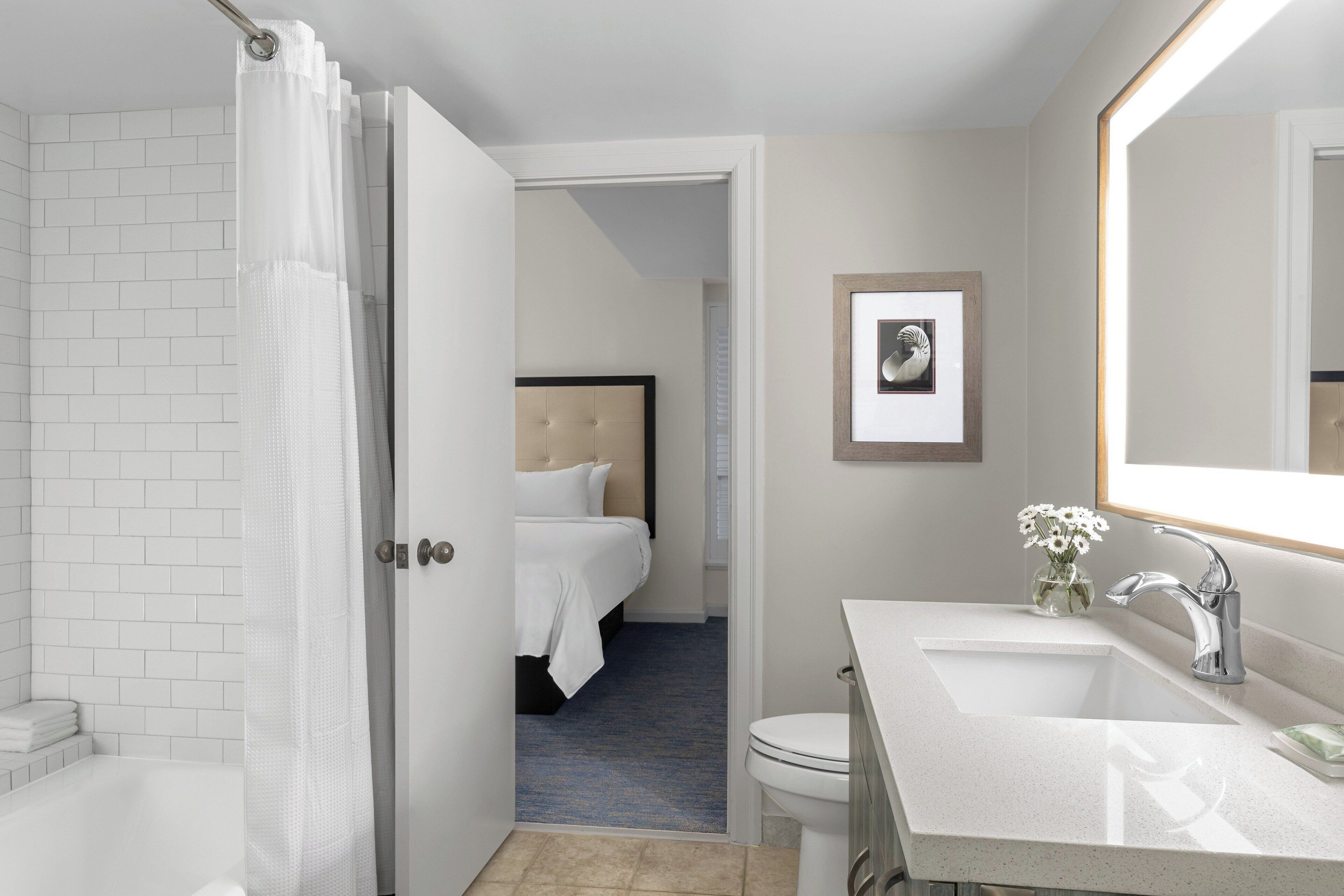 Une salle de bain d’hôtel équipée d’une douche, de toilettes et d’un lavabo.