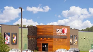 A building with a sign reading "SPARKTIME" and a parking lot with several cars.