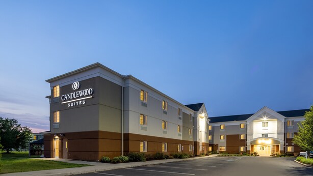Un hotel Candlewood Suites con un diseño moderno, que cuenta con varios pisos y una entrada bien iluminada.