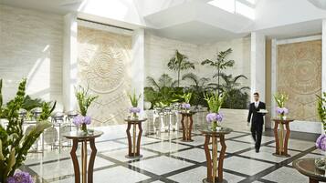 Eine großzügige Lobby mit hoher Decke, Marmorwänden und einem geometrischen Bodenmuster.