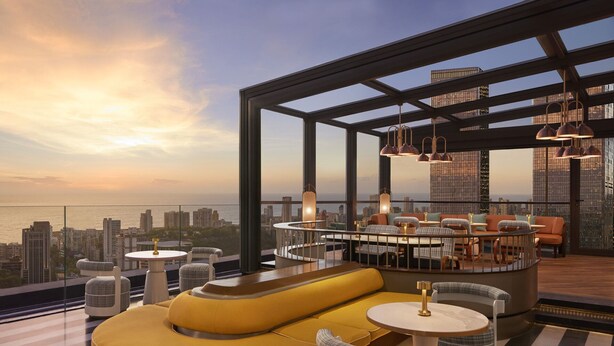 Un bar en la azotea con asientos y vistas del horizonte urbano.