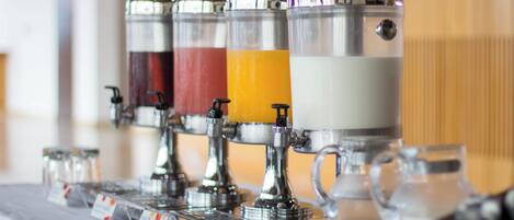 Ein Getränkespender mit verschiedenen Auswahlmöglichkeiten wie Milch, Saft und Wasser.