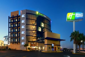 Ein Holiday Inn Express Hotel mit modernem Design, das eine geschwungene Fassade und große Fenster aufweist.