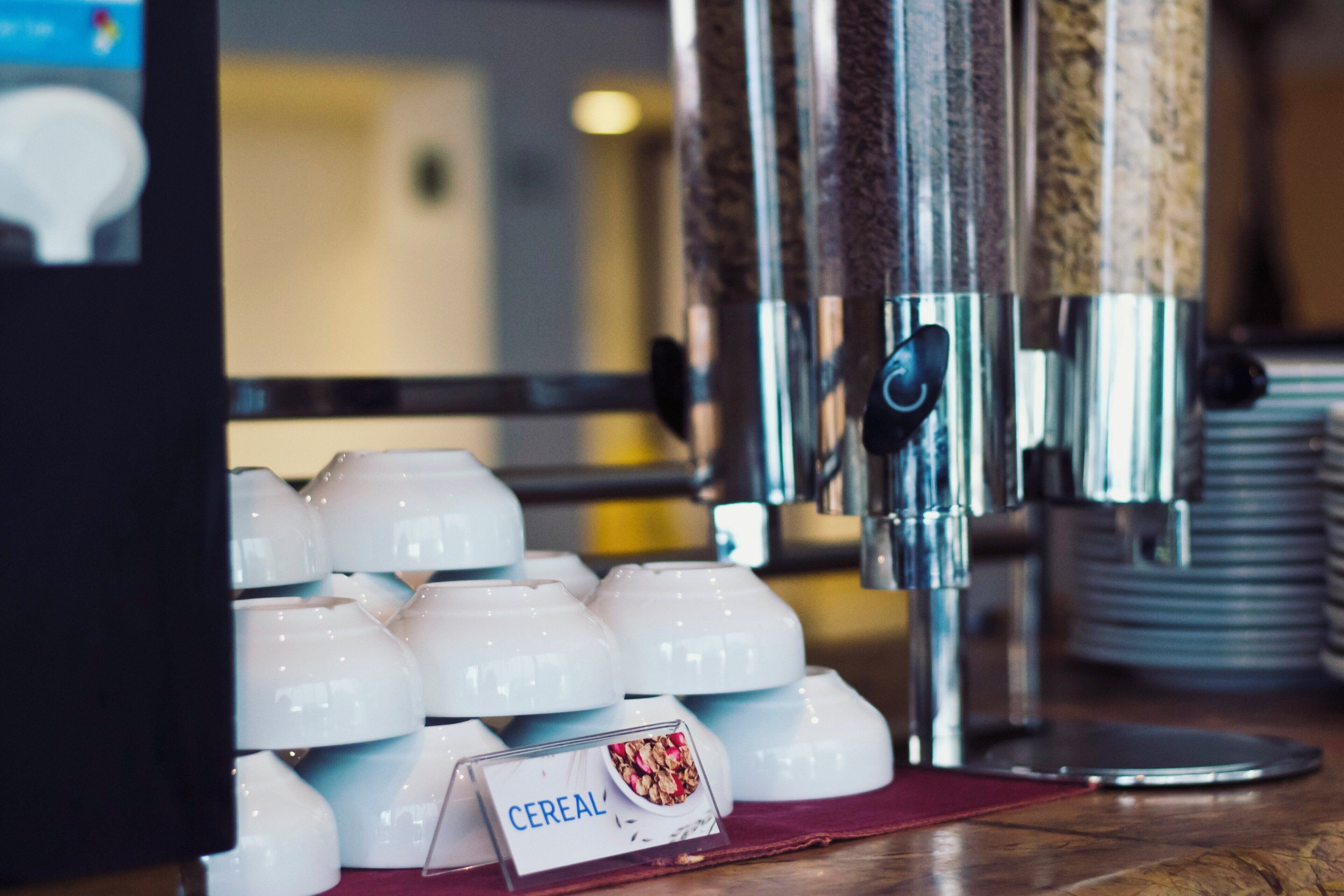 Un bufé de desayuno con una variedad de cereales y una máquina de café.