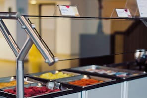 A self-service food station with labeled trays of various fruits and a metal utensil. - Holiday Inn Express Nuevo Laredo by IHG (Nuevo Laredo)