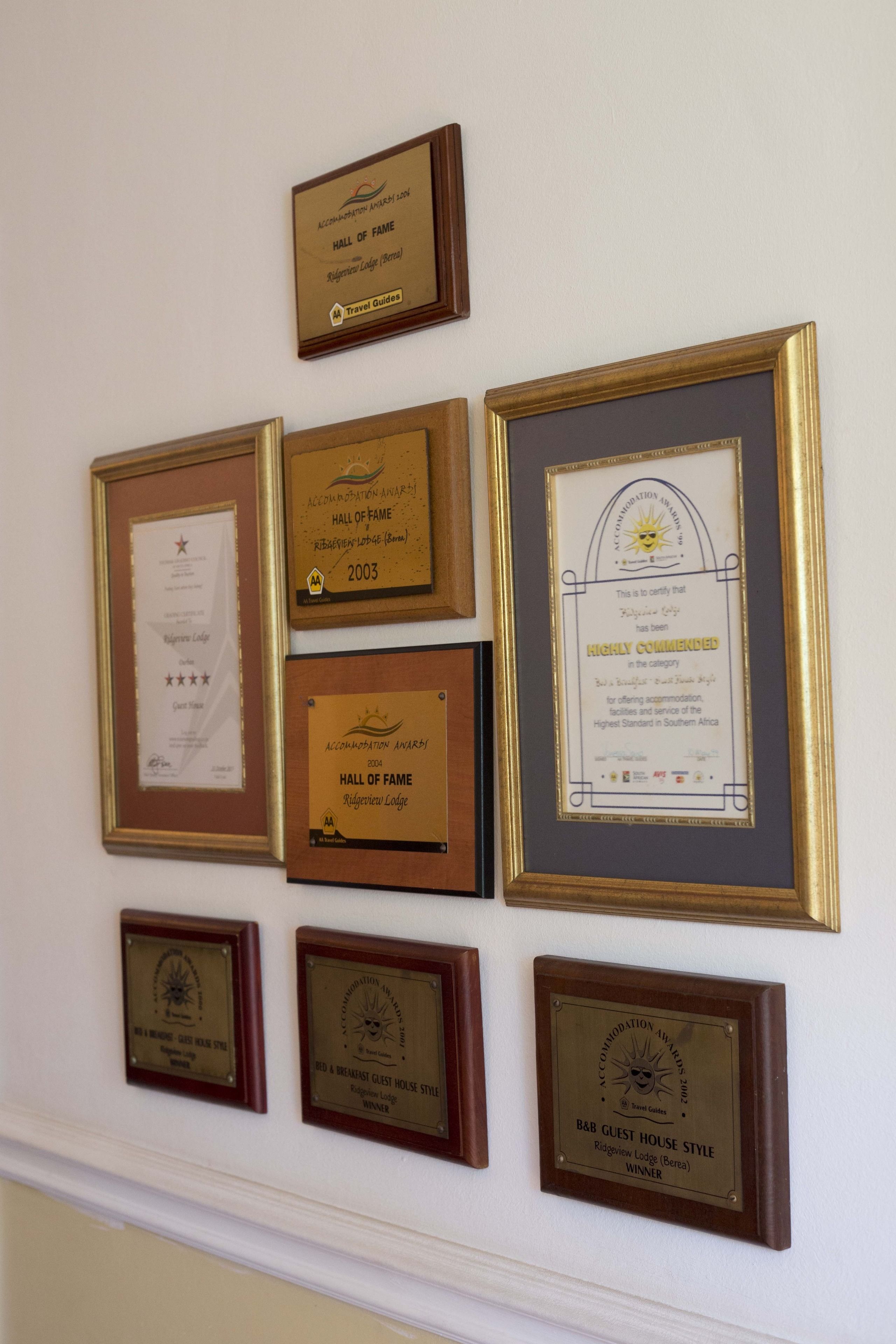 En vägg där ett flertal inramade utmärkelser och certifikat hänger.