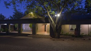 Ein Gebäude mit einem überdachten Eingang, Stufen, die hinaufführen, und ein Baum davor.