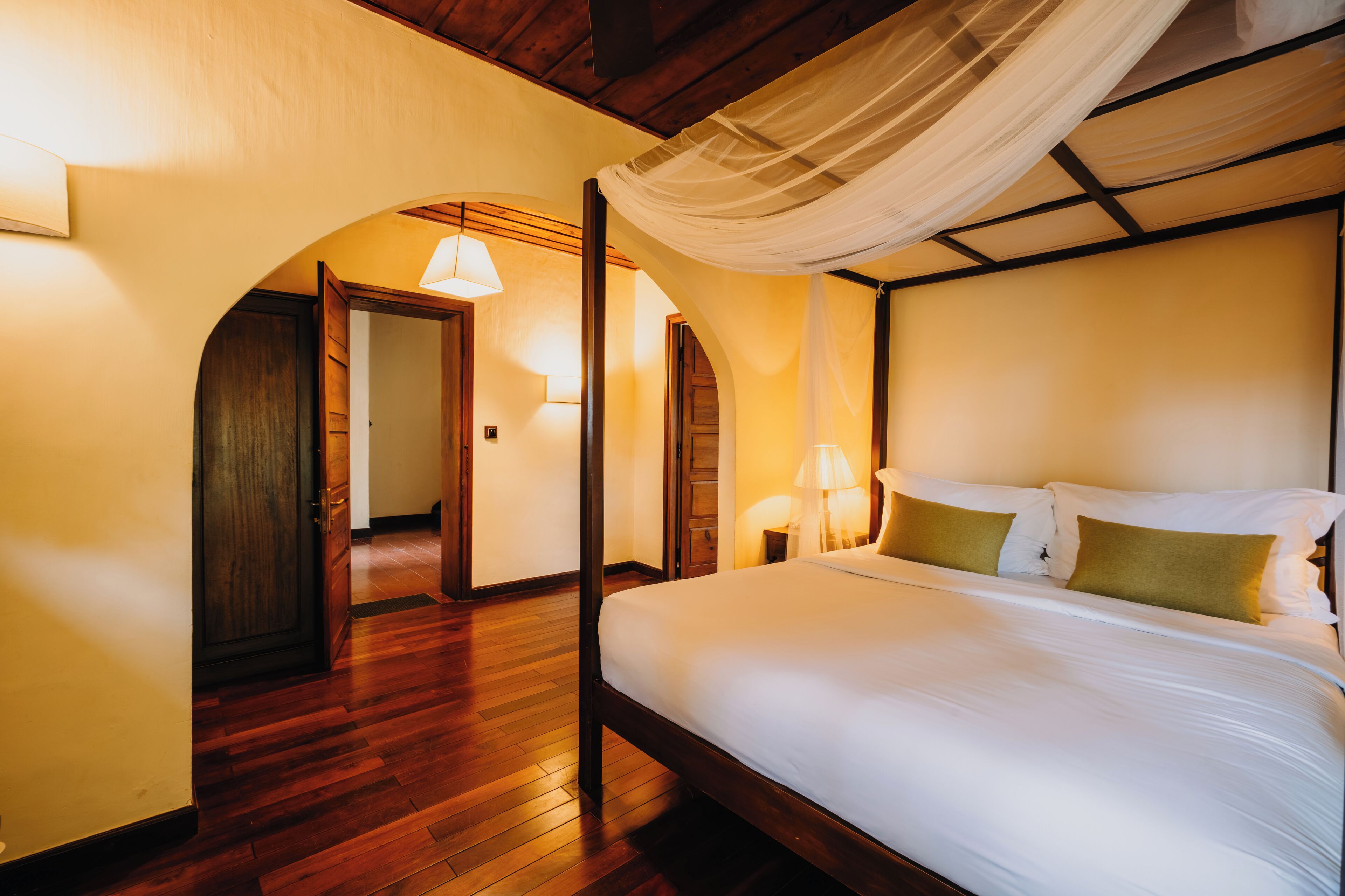 Une chambre à coucher avec un lit à baldaquin, un plancher en bois et un dais.