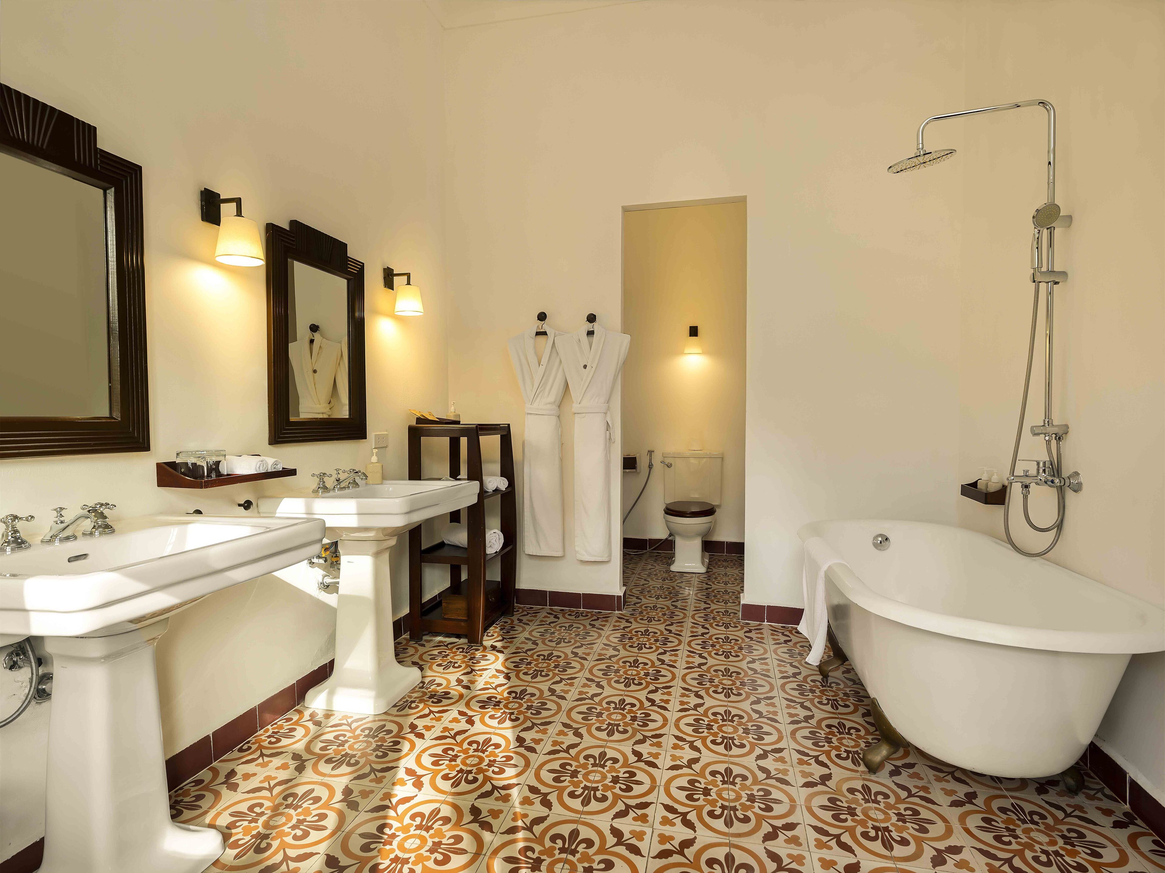 Un baño con dos lavamanos, inodoro, bañera y ducha.