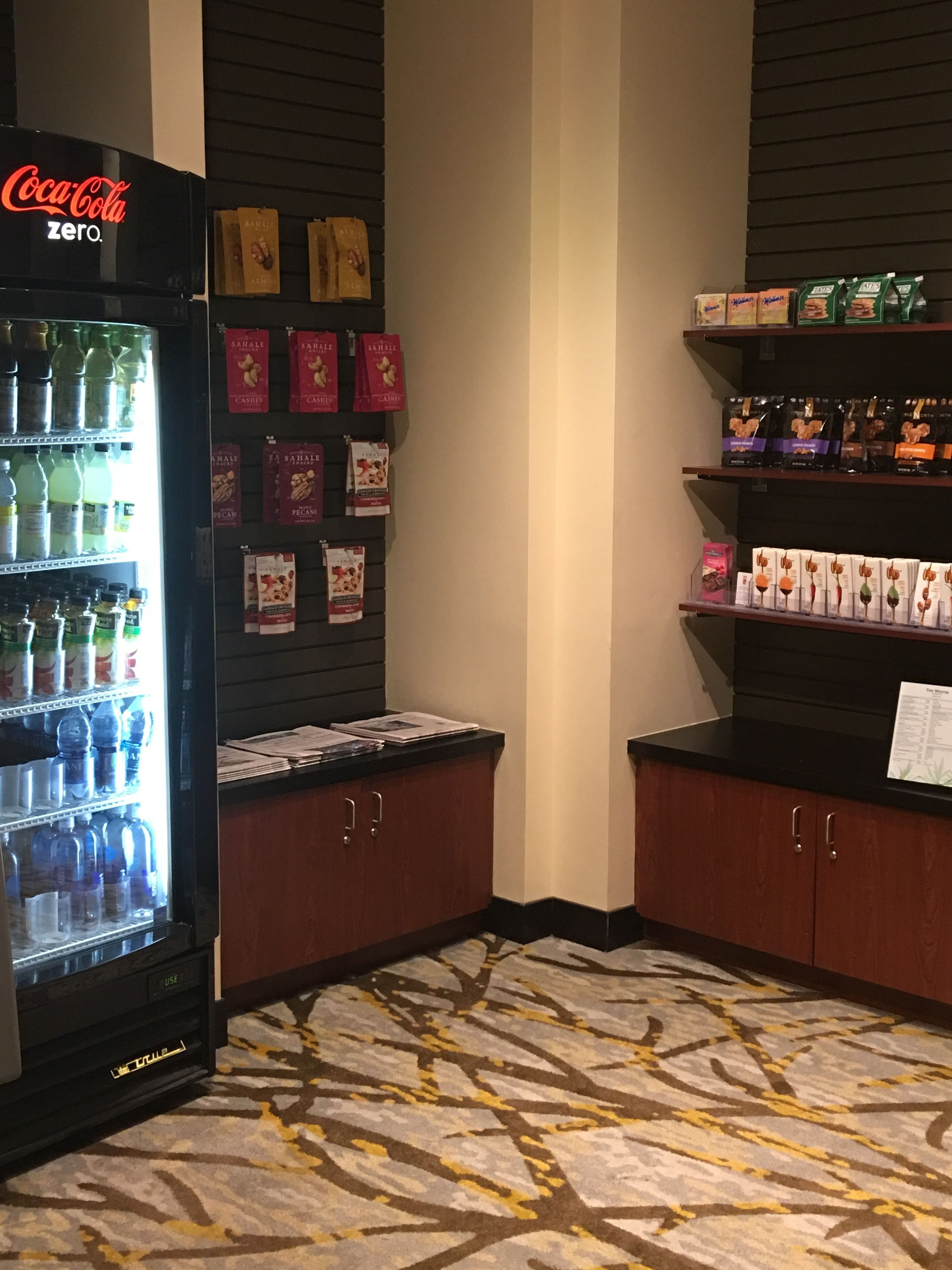 Zona de màquines expenedores amb una màquina de Coca-Cola Zero, envasos de llaminadura i aigua embotellada.