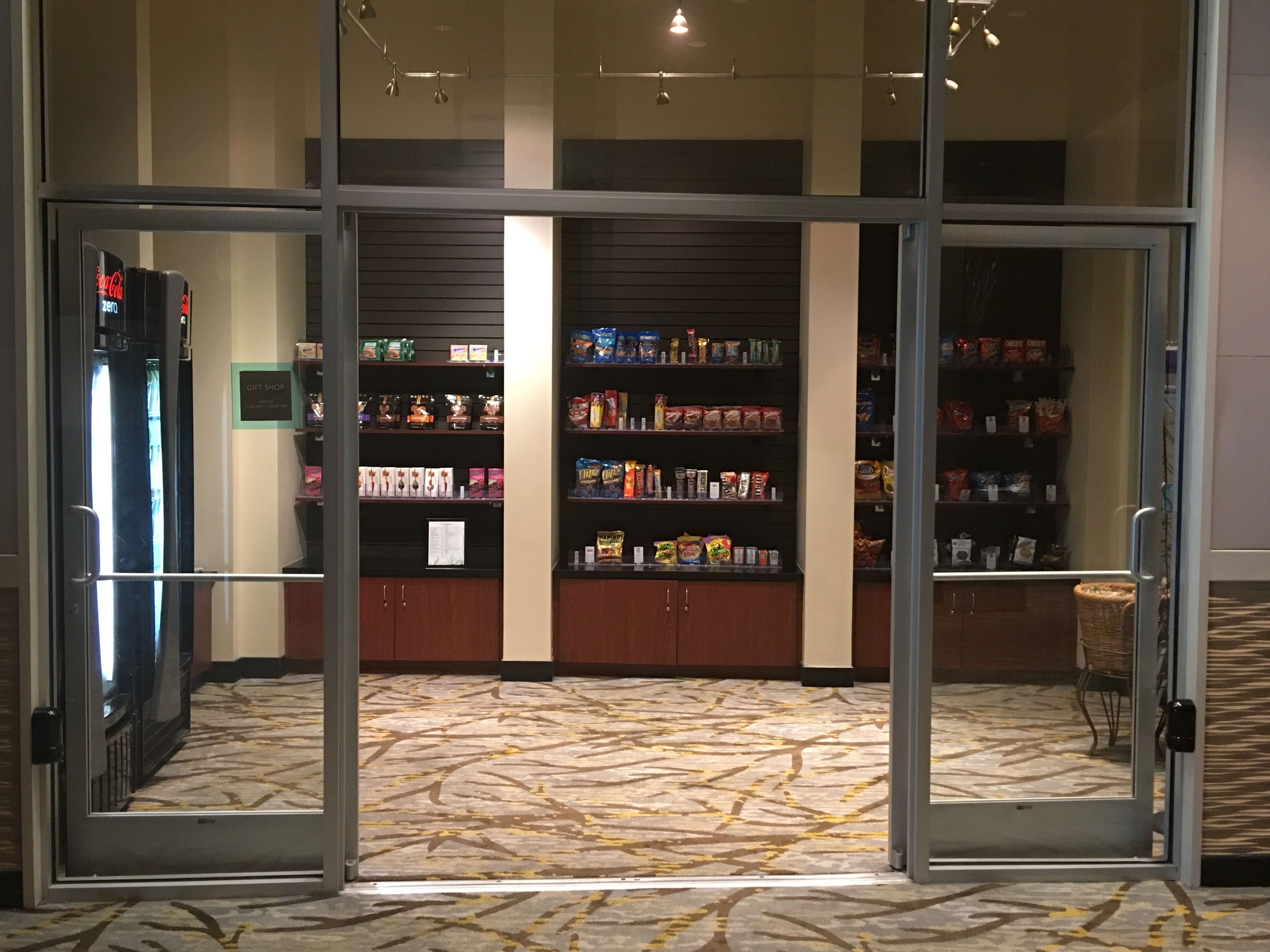 A gift shop with shelves of various items and a patterned carpet.