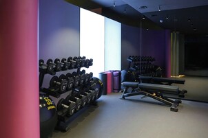 Ein Fitnessraum mit Kurzhanteln, einer Bank und Trainingsgeräten.