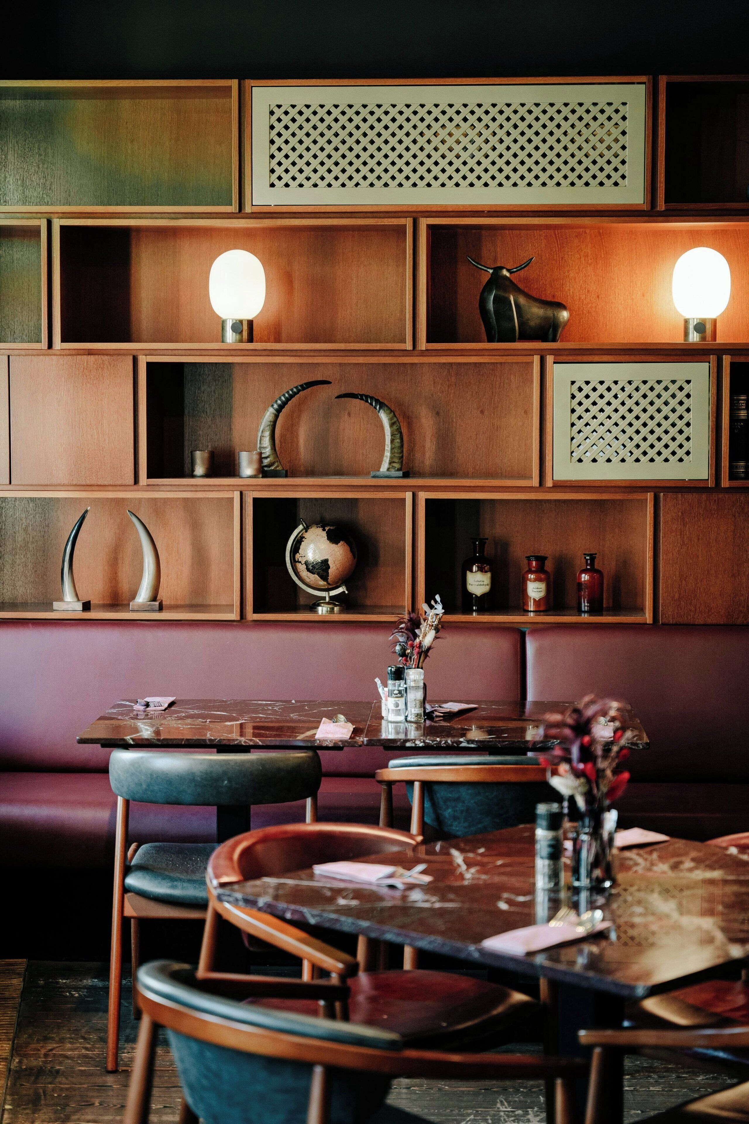 A restaurant with wooden shelves, a globe, and a bull sculpture.
