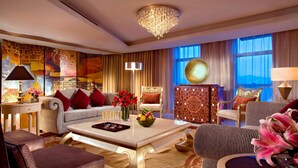 A luxurious living room with a chandelier, sofas, a coffee table, and decorative elements.